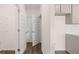 Hallway with multiple doors, leading to various rooms and featuring hardwood floors at 235 Silver Moon Dr, Loganville, GA 30052