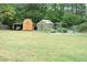 Spacious backyard with a wooden fence, greenhouse, and shed, providing a private and functional outdoor space at 3824 Smith Creek Ct, Buford, GA 30519