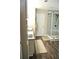 A well-lit bathroom with wood-look flooring, a gray-tiled shower, and a modern vanity at 3824 Smith Creek Ct, Buford, GA 30519