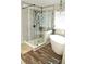 A bathroom with a frameless glass shower, soaking tub, and stylish dark fixtures at 3824 Smith Creek Ct, Buford, GA 30519