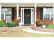 Welcoming front entrance with a charming floral wreath, lush plants and manicured landscaping at 3824 Smith Creek Ct, Buford, GA 30519