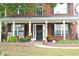 Inviting front porch with lush plants, stylish decor, and an elegant entrance to a brick home at 3824 Smith Creek Ct, Buford, GA 30519