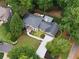 Aerial view of a home showcasing its landscaped yard, deck, and proximity to a creek and wooded area at 4249 Arbor Club Dr, Marietta, GA 30066