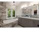 Modern bathroom featuring a large soaking tub, dual sink vanity with marble countertops, and a stunning chandelier at 4249 Arbor Club Dr, Marietta, GA 30066
