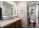 Modern bathroom featuring a wood vanity, a large mirror with modern lighting, and a toilet in a separate room at 4249 Arbor Club Dr, Marietta, GA 30066