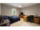 A simple bedroom featuring carpet, ceiling fan, and a desk with natural light streaming through the window at 4249 Arbor Club Dr, Marietta, GA 30066