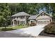 Well-maintained home features a spacious driveway leading to an attached garage, set amongst lush greenery at 4249 Arbor Club Dr, Marietta, GA 30066