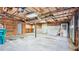 View of the unfinished garage showing open ceilings, concrete floor and two garage doors at 536 Cherokee Overlook Court Ct, Canton, GA 30115