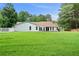Expansive backyard with lush green grass, bordered by a white picket fence and mature trees for privacy at 145 Deep Step Rd, Covington, GA 30014