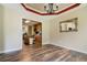 Elegant dining room features wood floors, a decorative ceiling, and views into the kitchen area at 145 Deep Step Rd, Covington, GA 30014