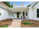 Inviting front porch with white pillars, a cozy bench, and manicured landscaping welcomes visitors at 145 Deep Step Rd, Covington, GA 30014