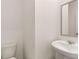 Well-lit bathroom with a pedestal sink and a toilet at 245 Silver Moon Dr, Loganville, GA 30052