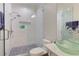 This bathroom features a shower, toilet, and a double sink vanity with see-through green vessel sinks at 2972 Lookout Ne Pl, Atlanta, GA 30305