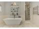 Bright bathroom featuring a soaking tub with glass shelving and a glass shower with marble tile at 2972 Lookout Ne Pl, Atlanta, GA 30305