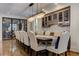Spacious dining room featuring a long table, hardwood floors, glass enclosed wine storage and crystal chandelier at 2972 Lookout Ne Pl, Atlanta, GA 30305