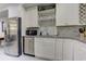 A modern kitchenette features stainless steel appliances, light granite counters, and light backsplash at 2972 Lookout Ne Pl, Atlanta, GA 30305