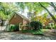 Brick house with a two-car garage, surrounded by lush landscaping and mature trees at 6203 Crestview Drive Southeast Se Dr, Covington, GA 30014
