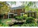 Expansive backyard with lush greenery, a charming water feature, and a beautiful brick home facade at 6203 Crestview Drive Southeast Se Dr, Covington, GA 30014