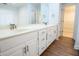 Bathroom with wood look floors, a dual sink vanity, and framed mirror at 6203 Crestview Drive Southeast Se Dr, Covington, GA 30014