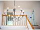 Chandelier hanging over a foyer balcony featuring white walls and natural lighting at 6203 Crestview Drive Southeast Se Dr, Covington, GA 30014