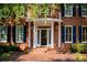 Close-up of a brick home's covered entryway with white columns and a storm door at 6203 Crestview Drive Southeast Se Dr, Covington, GA 30014