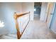 Staircase with white carpet and wooden railing leading to a bright upstairs hallway with doorways at 6203 Crestview Drive Southeast Se Dr, Covington, GA 30014