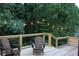 Cozy deck with string lights, wood railings, black iron balusters, and two Adirondack chairs at 6878 Vic Ar Rd, Atlanta, GA 30360