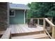 Back porch with natural wood railings, black iron balusters, and two Adirondack chairs at 6878 Vic Ar Rd, Atlanta, GA 30360