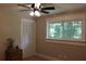 This bedroom has a beautiful window, ceiling fan, and closet with louvered doors at 6878 Vic Ar Rd, Atlanta, GA 30360