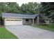 Charming home showcasing stone accents, a gray roof, a spacious two-car garage, and a well-manicured lawn at 6878 Vic Ar Rd, Atlanta, GA 30360