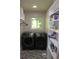 Well-organized laundry room with storage shelving and modern washer and dryer at 6878 Vic Ar Rd, Atlanta, GA 30360