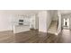 Open-concept living space with wood floors, white cabinets, stainless steel appliances, and a staircase at 225 Silver Moon Dr, Loganville, GA 30052