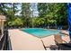 Community pool area featuring lounge chairs, tables, and lush landscaping at 3650 Ashford Dunwoody Ne Rd # 413, Atlanta, GA 30319