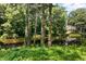 Scenic wooded waterfront view showcases a beautiful home overlooking the serene lake with mature trees at 3650 Ashford Dunwoody Ne Rd # 413, Atlanta, GA 30319