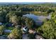 Aerial view of homes and a lake surrounded by lush trees on a sunny day at 1077 Mainstreet Valley Dr, Stone Mountain, GA 30088