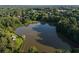 A long distance aerial view of a lake and some homes surrounded by a dense forest of trees at 1077 Mainstreet Valley Dr, Stone Mountain, GA 30088