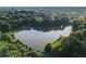 Aerial photo looking down on a lake surrounded by lush forest and some grassy banks at 1077 Mainstreet Valley Dr, Stone Mountain, GA 30088
