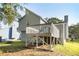Back of house showing elevated deck overlooking a grass lawn with mature trees in the background at 1077 Mainstreet Valley Dr, Stone Mountain, GA 30088