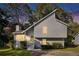 Charming home featuring unique architectural design, green door and landscaped yard at sunset at 1077 Mainstreet Valley Dr, Stone Mountain, GA 30088