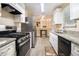 Contemporary kitchen featuring stainless steel appliances and view into the living space at 1077 Mainstreet Valley Dr, Stone Mountain, GA 30088