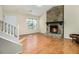 Bright living room showcasing wood floors, stone fireplace, and staircase at 1077 Mainstreet Valley Dr, Stone Mountain, GA 30088