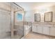 Luxurious bathroom featuring a walk-in shower, soaking tub, dual vanities, and elegant tile work at 253 Orchard Trl, Holly Springs, GA 30115