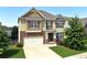 Charming two-story home with stone accents, a well-manicured lawn, and a two-car garage at 253 Orchard Trl, Holly Springs, GA 30115