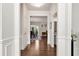 Bright hallway with hardwood floors leading to an open floor plan dining room and kitchen at 253 Orchard Trl, Holly Springs, GA 30115