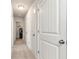 Hallway with multiple doors, one leading to the laundry room, and neutral walls at 253 Orchard Trl, Holly Springs, GA 30115