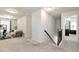 Well-lit hallway with carpet flooring, staircase, and views of an exercise room and bedroom at 253 Orchard Trl, Holly Springs, GA 30115