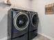 Laundry room featuring modern black washer and dryer units, and additional storage at 253 Orchard Trl, Holly Springs, GA 30115