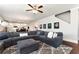 Comfortable living room boasts a large sectional sofa, ceiling fan, and an open floorplan with hardwood floors at 253 Orchard Trl, Holly Springs, GA 30115