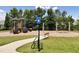 Community playground featuring swings, slides, and benches is surrounded by lush green grass at 253 Orchard Trl, Holly Springs, GA 30115