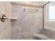 Detailed view of a tiled walk-in shower with a built-in bench and stylish fixtures at 253 Orchard Trl, Holly Springs, GA 30115